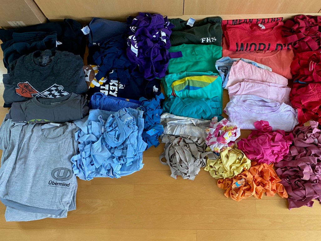A full spectrum of used T-shirts and T-shirt rags arrayed on the floor
