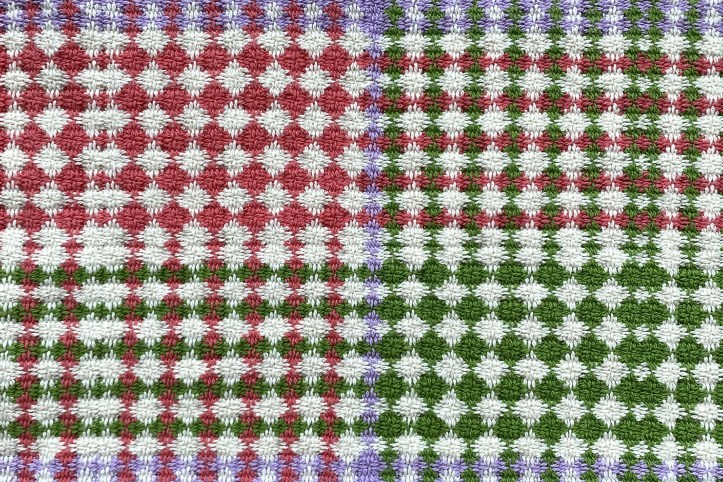 Cloth with a woven diamond effect in large blocks of pink and green against white